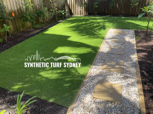 Synthetic turf laid around pavers and stepping stones