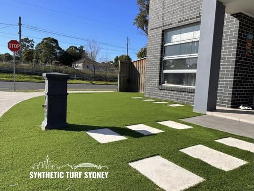 Synthetic turf laid around pavers and stepping stones