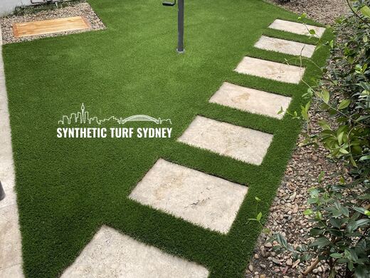Synthetic turf laid around pavers and stepping stones