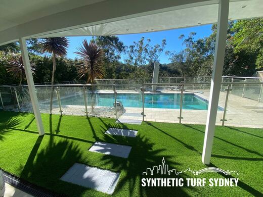 Synthetic turf laid around pavers and stepping stones