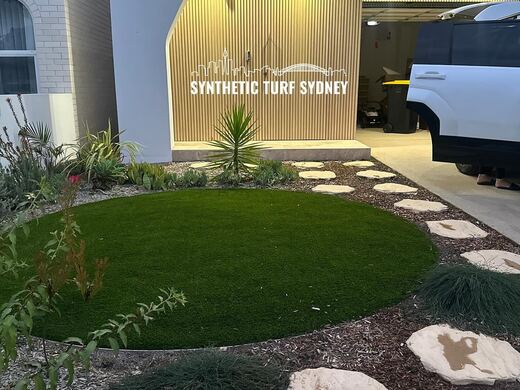 Synthetic turf laid around pavers and stepping stones