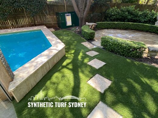 Synthetic turf laid around pavers and stepping stones
