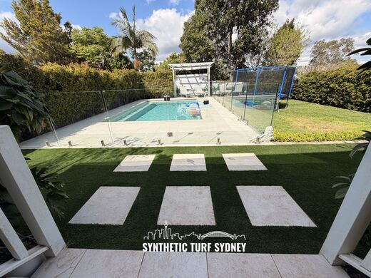Synthetic turf laid around pavers and stepping stones