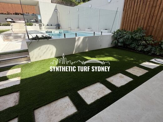 Synthetic turf laid around pavers and stepping stones