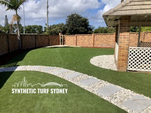 Synthetic turf laid around pavers and stepping stones