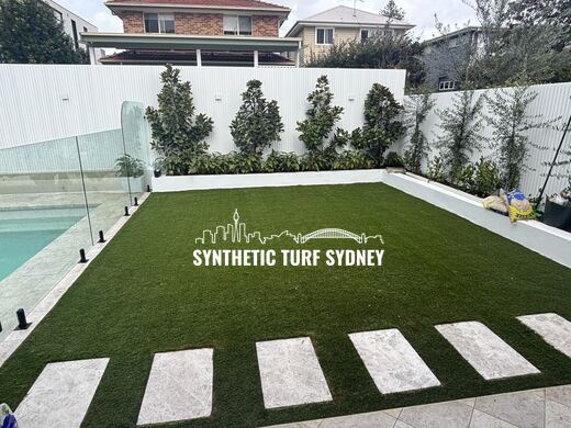 Synthetic turf laid around pavers and stepping stones
