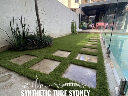 Synthetic turf laid around pavers and stepping stones