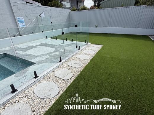Lawn and pebble border beside a pool, laid in Collaroy 40mm synthetic turf