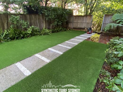 Lawn and stepping stones beside a deck, laid in Collaroy 40mm synthetic turf