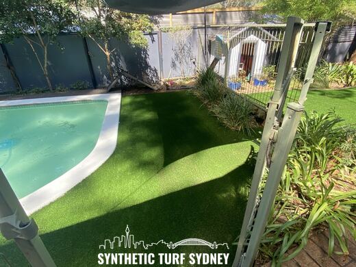 Lawn beside a pool under a shade sail, laid in Collaroy 40mm synthetic turf