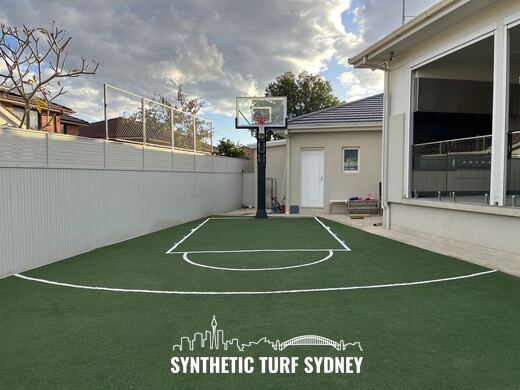 Marked half court beside a glass wall, laid in STS Commercial synthetic turf