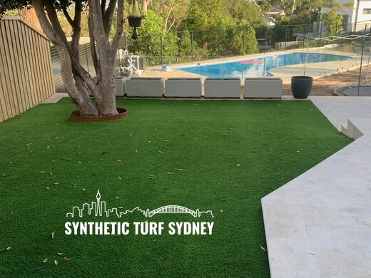 Lawn under a tree beside a pool, laid in Collaroy 40mm synthetic turf