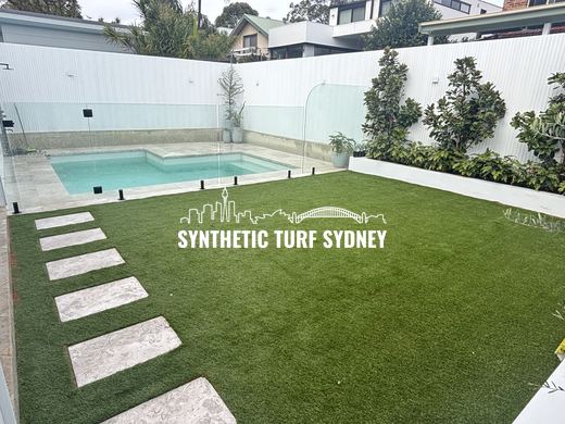 Synthetic turf laid around pavers and stepping stones