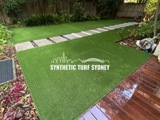 Synthetic turf laid around pavers and stepping stones