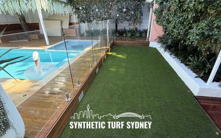 Lawn beside a fenced pool and deck, laid in Collaroy 40mm synthetic turf