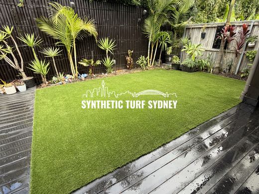 Lawn beyond a grey timber deck, laid in Hyde Park 40mm synthetic turf