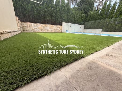 Lawn beside a lap pool and sandstone wall, laid in Collaroy 40mm synthetic turf